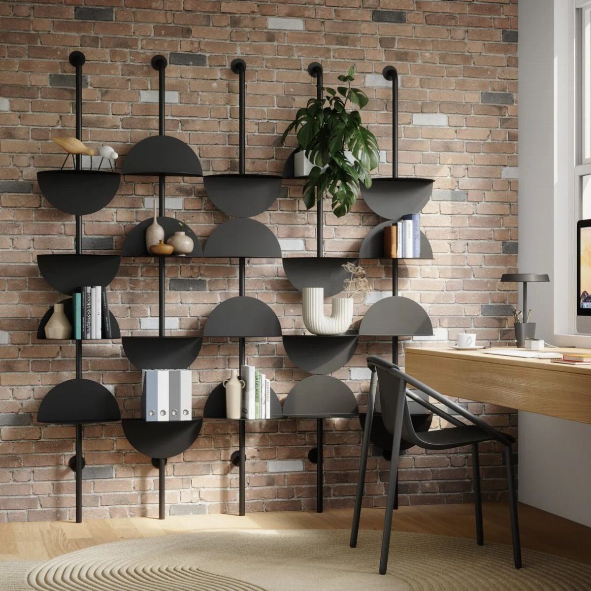 Black semi-circular shelves mounted on a brick wall holding books and plants.