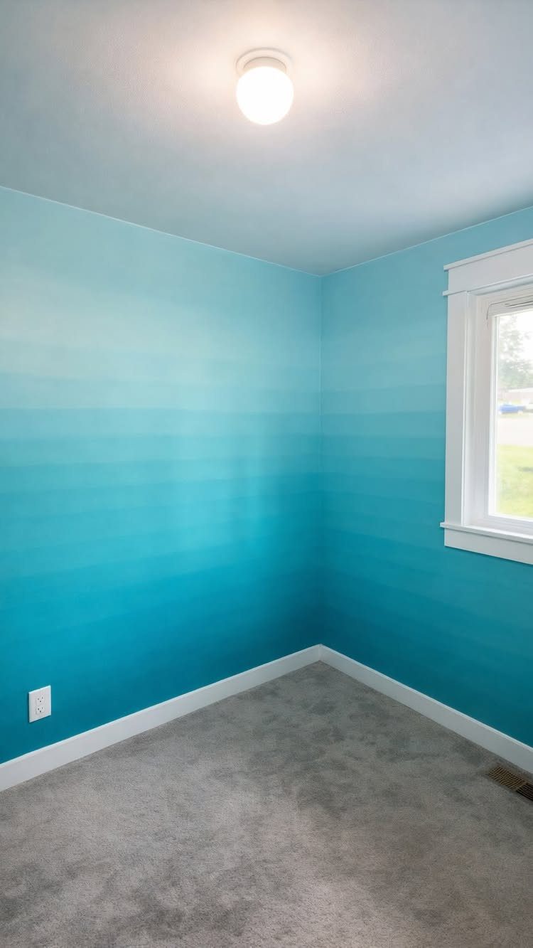 An empty room featuring a turquoise ombre accent wall transitioning from light to dark blue.