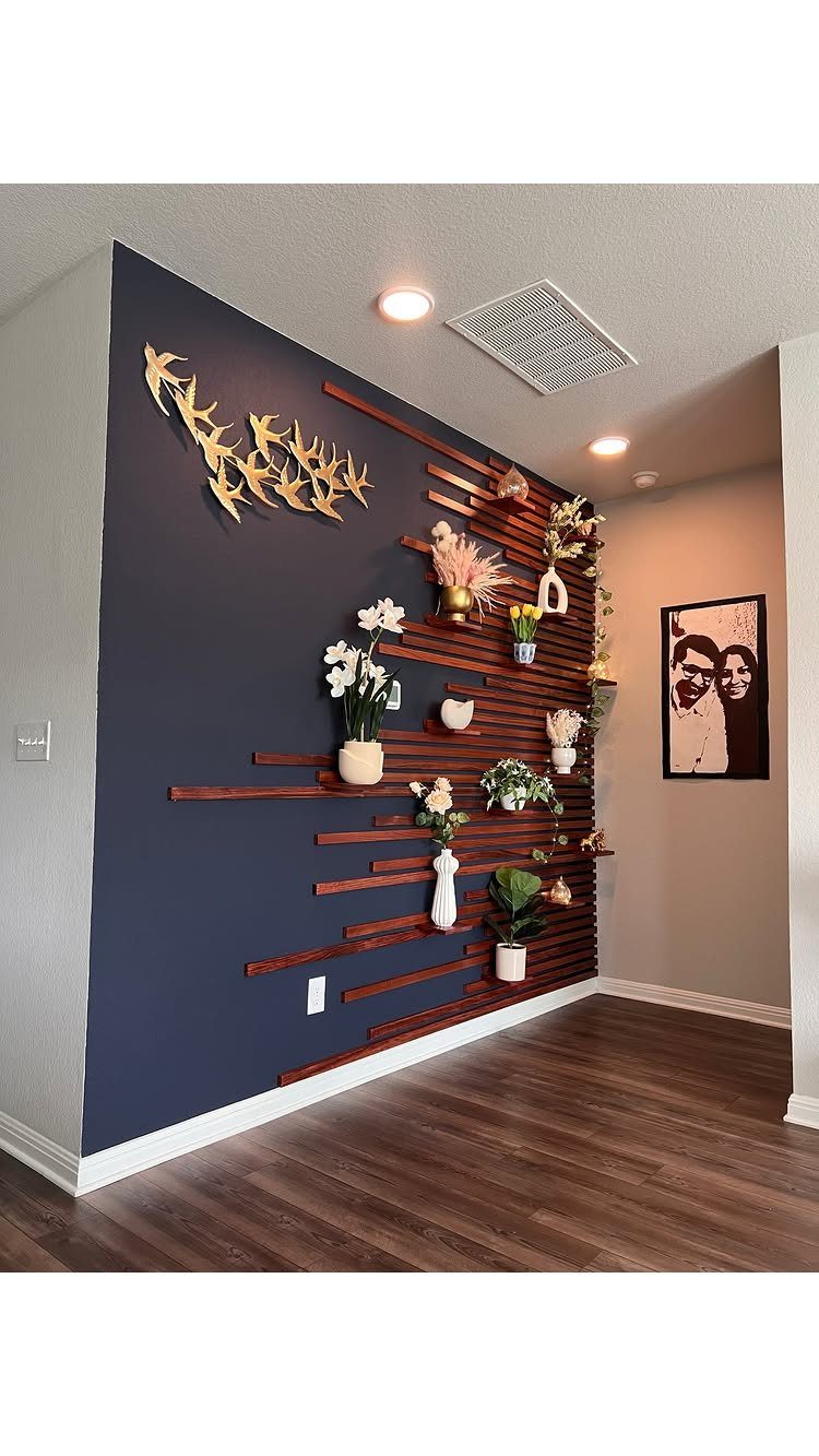 Dark navy blue accent wall featuring horizontal wooden slats and various small potted plants.