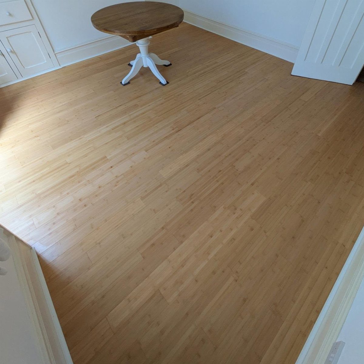 10 Affordable Flooring Ideas for Every Room in 2026 9 Light-colored bamboo wood flooring planks in a room with a small wooden table.