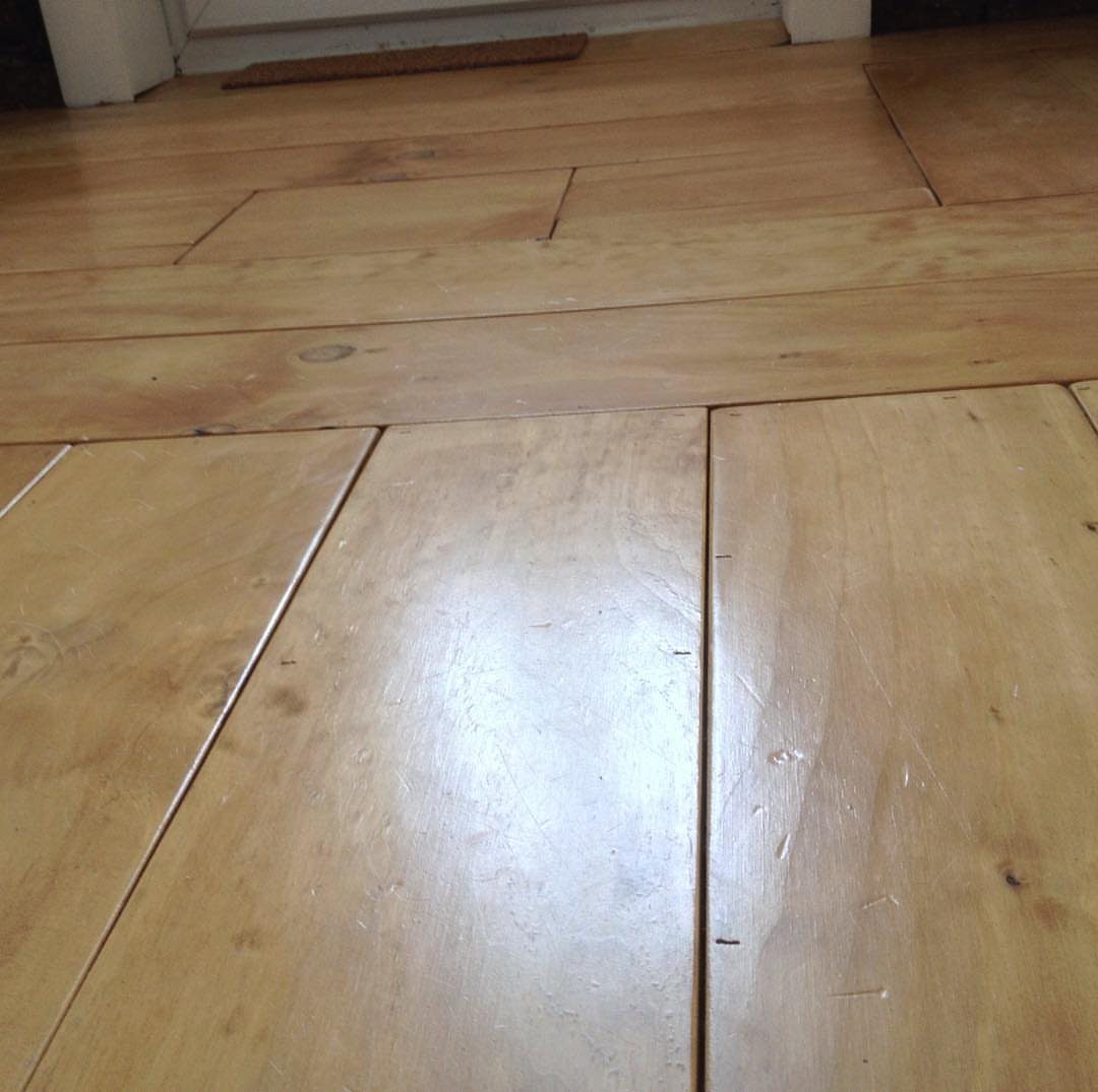 10 Affordable Flooring Ideas for Every Room in 2026 3 Light-colored wooden planks with visible grain covering a polished floor surface.