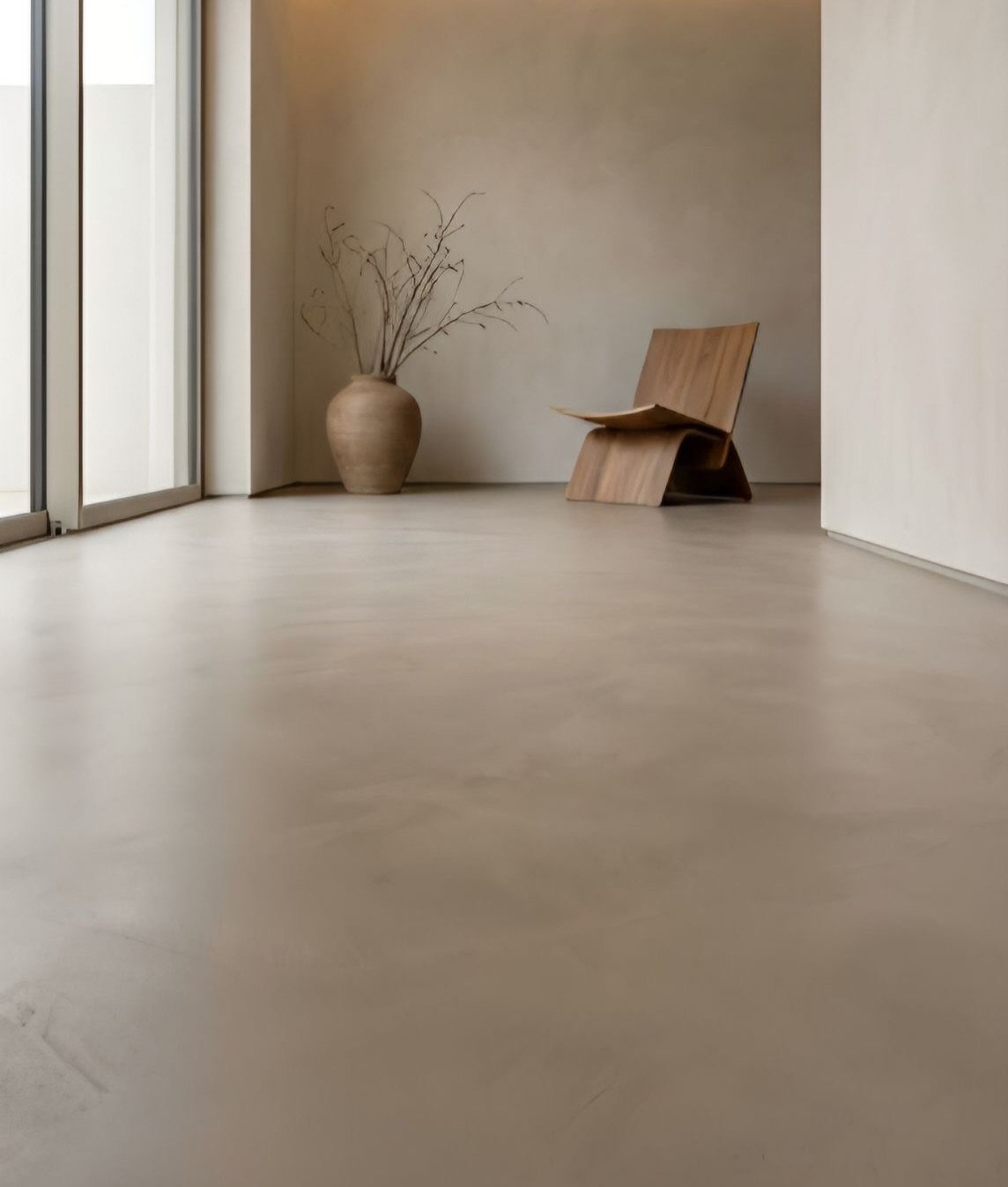 10 Affordable Flooring Ideas for Every Room in 2026 7 Smooth polished concrete flooring in a minimalist room with a wooden chair and vase.