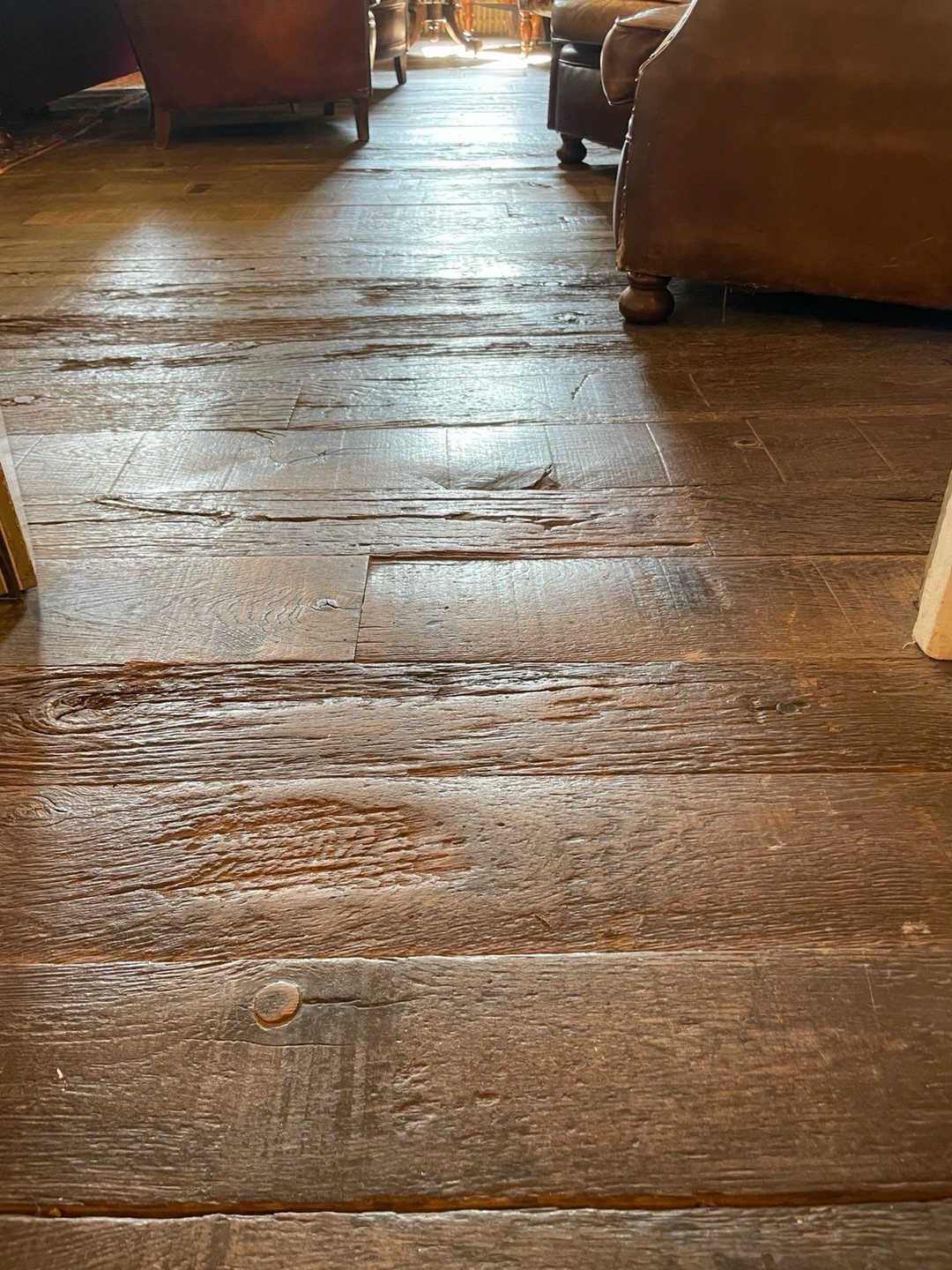 10 Affordable Flooring Ideas for Every Room in 2026 4 Weathered dark wood planks of reclaimed hardwood flooring with visible grain and texture.
