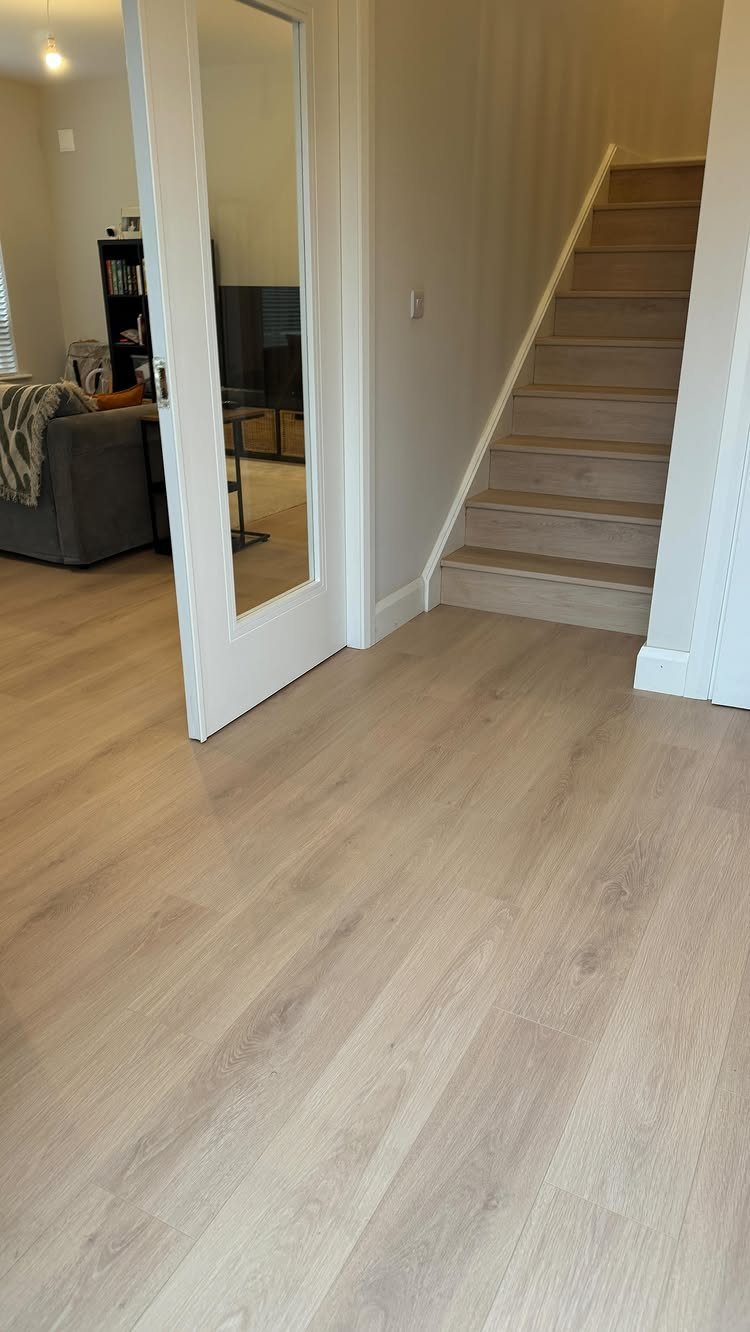 Cool Tone Wood Floors: 6 Mix-and-Match Ideas for Modern Matches 4 Light grey wood laminate flooring extends across a room and up a set of stairs.