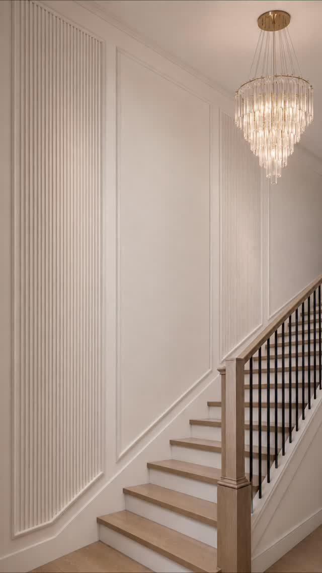 Decorative Wall Molding: 7 Panel Styles for Every Room 7 Cream walls with decorative rectangular molding and fluted vertical panels next to a wooden staircase.