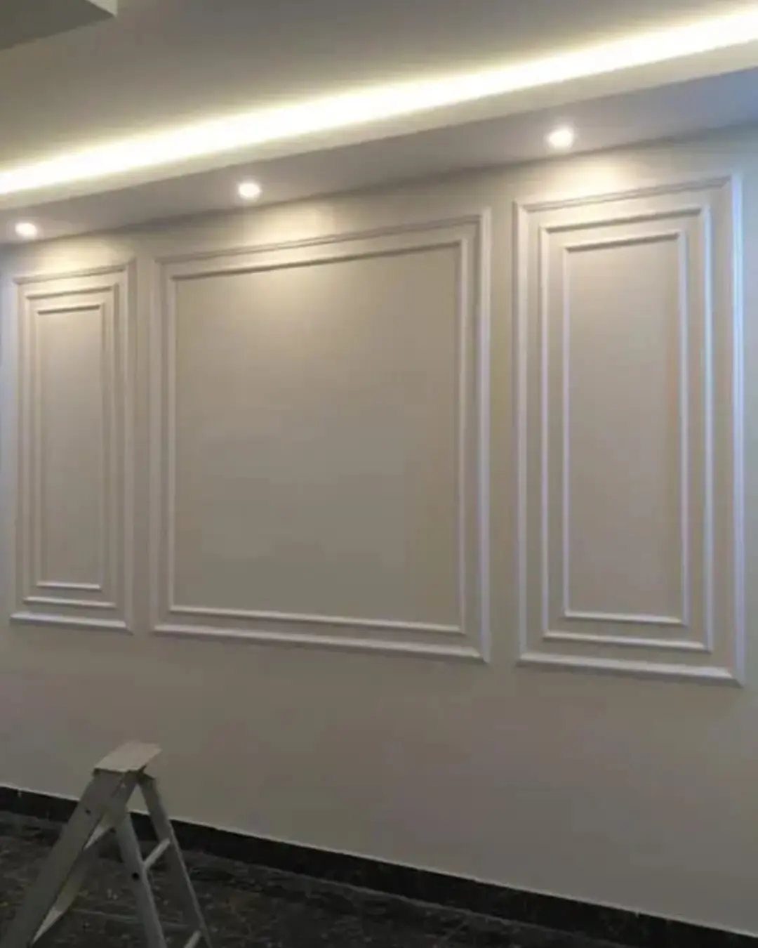 Decorative Wall Molding: 7 Panel Styles for Every Room 2 Three rectangular picture frame moldings installed on a light-colored interior wall under ceiling lighting.