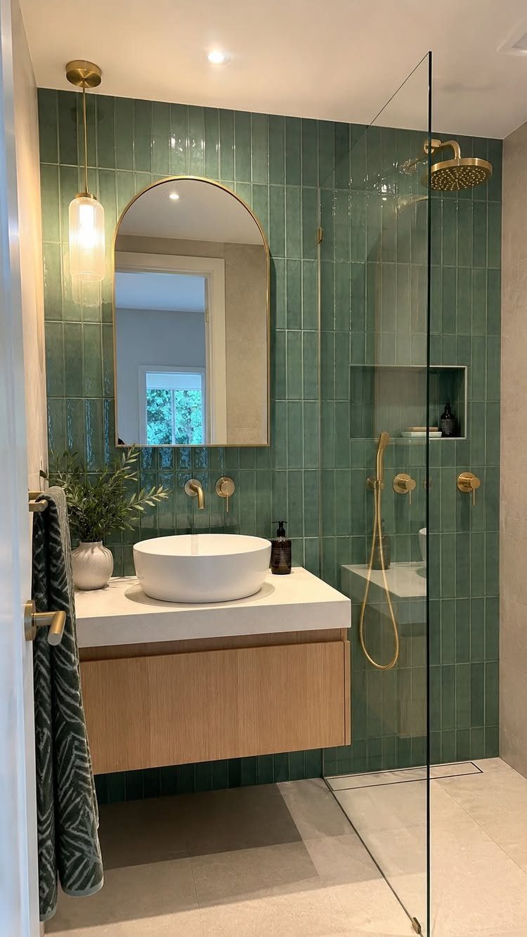 15 Feature Wall Ideas That Rely on Material, Not Just Color 7 Green vertical ceramic tiles covering a bathroom wall behind a white sink and wooden vanity.