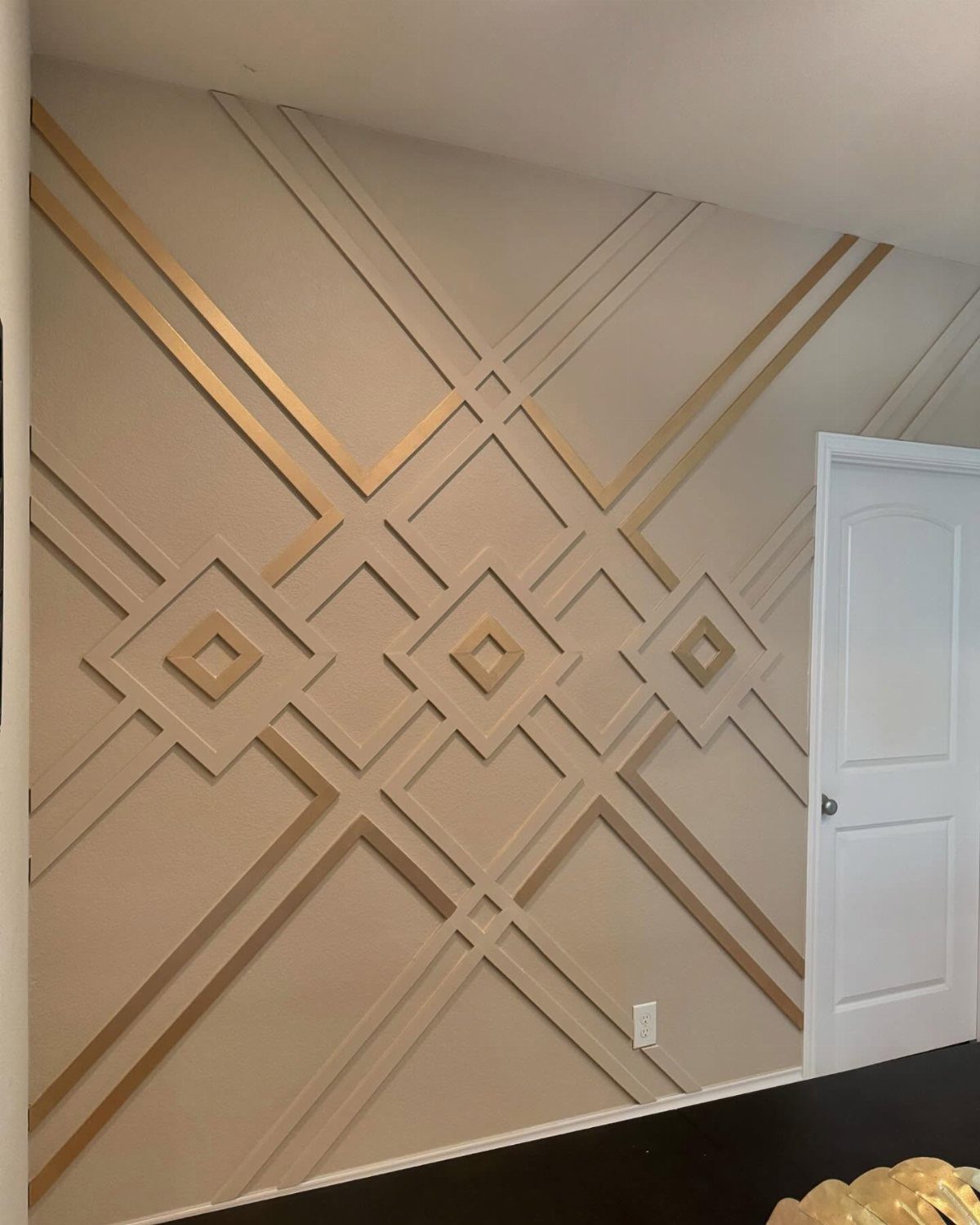 15 Feature Wall Ideas That Rely on Material, Not Just Color 14 Geometric gold trim forming a diamond pattern on a beige accent wall.