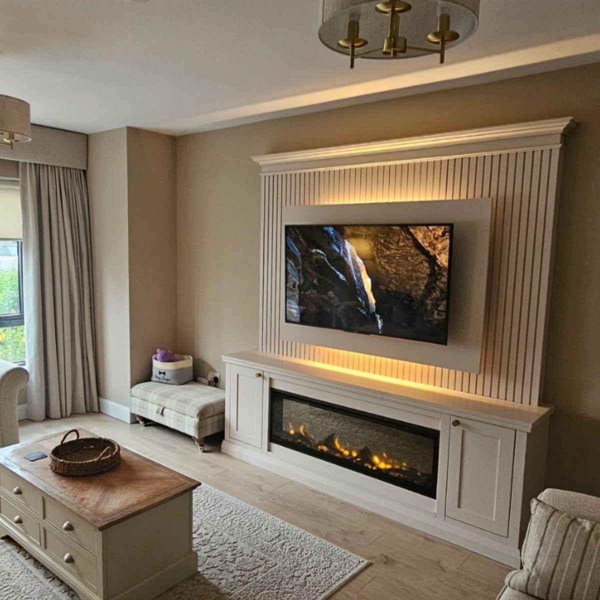 15 Feature Wall Ideas That Rely on Material, Not Just Color 3 White paneled entertainment unit with a built-in television and an electric fireplace in a living room.