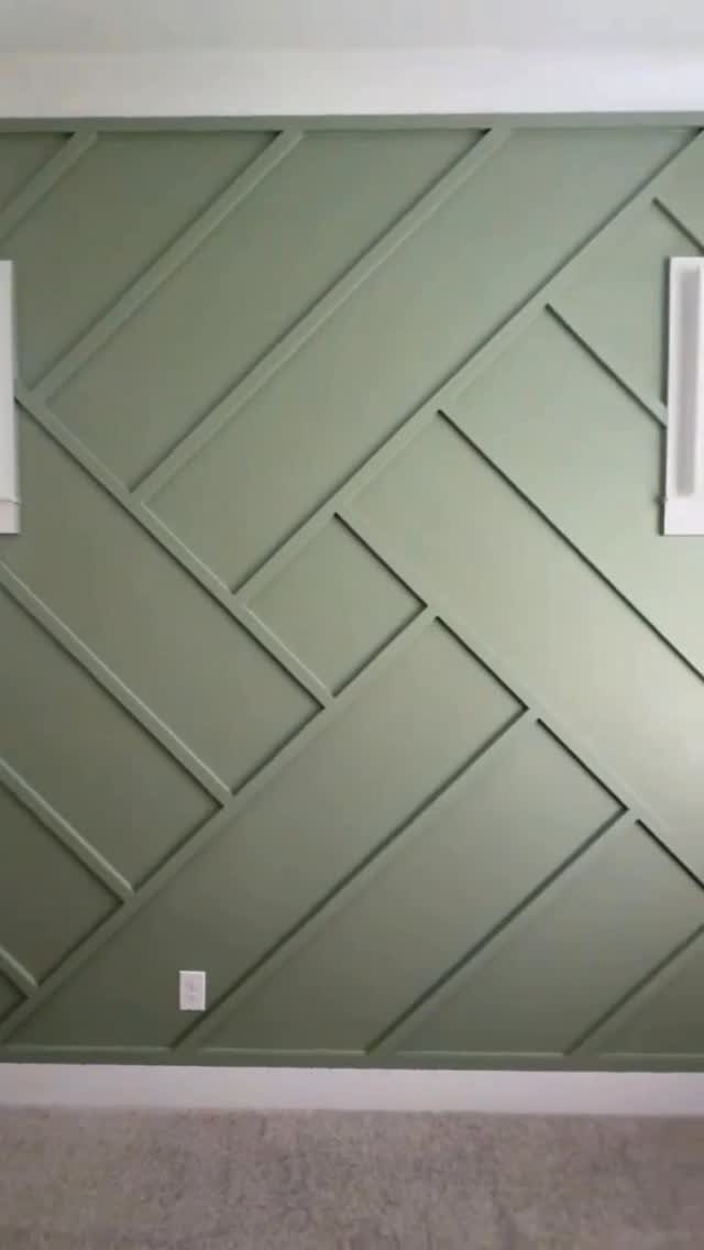 Sage green accent wall with a raised geometric pattern made of thin wooden slats.