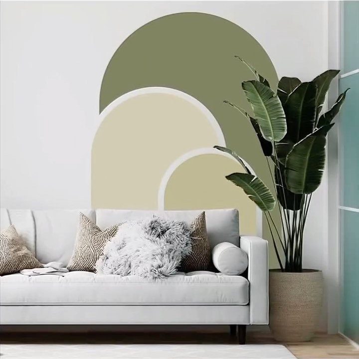 White sofa with textured pillows positioned in front of large painted boho arches.