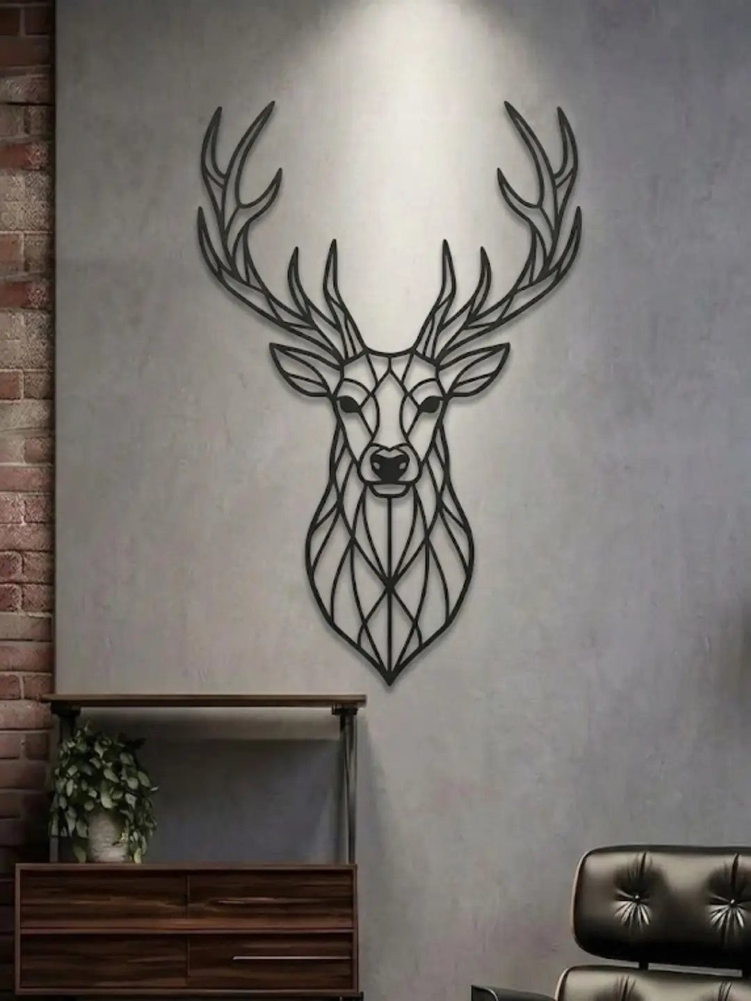Black geometric metal stag head sculpture mounted on a grey textured interior wall.