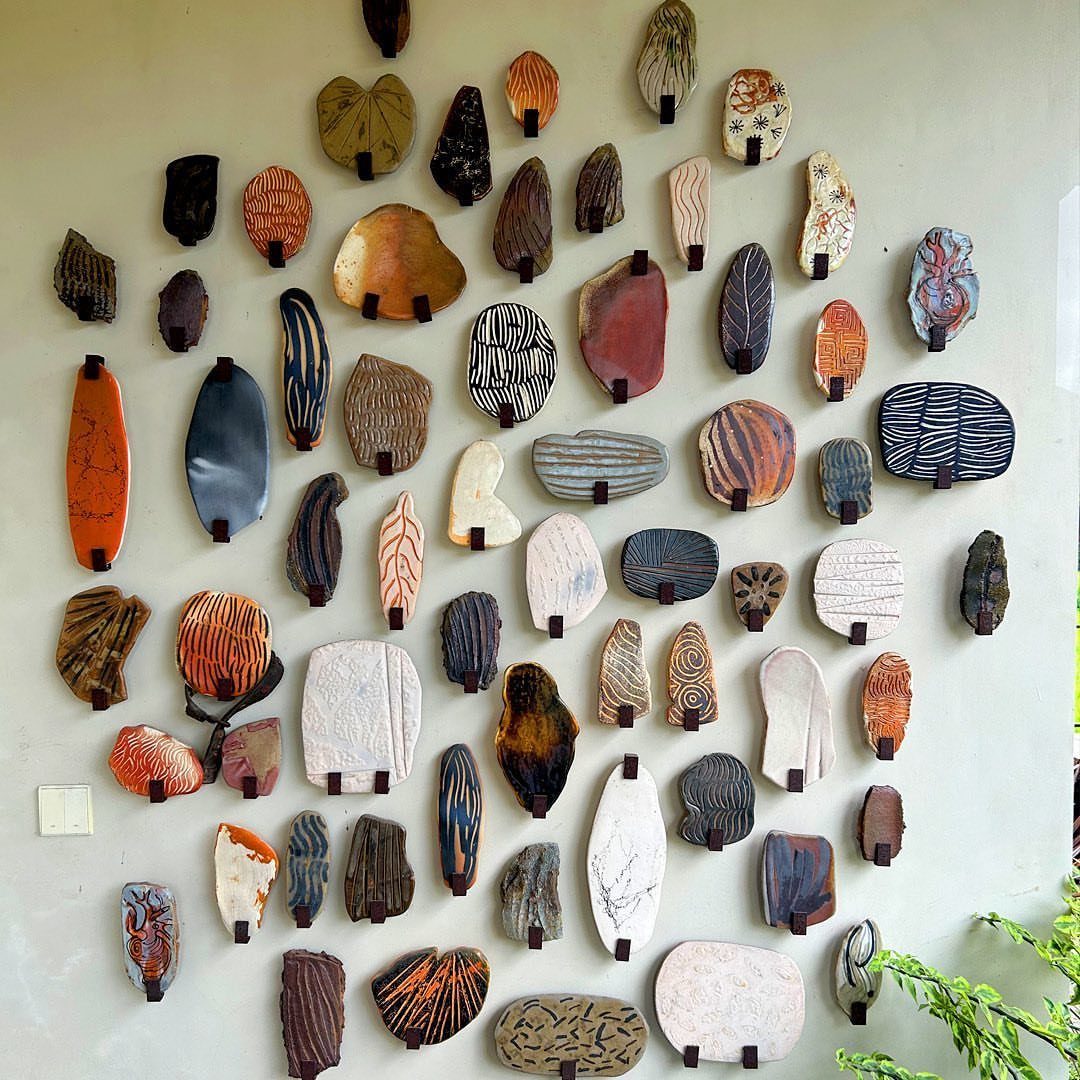 Various patterned ceramic wall art pieces arranged in a decorative cluster on a light wall.