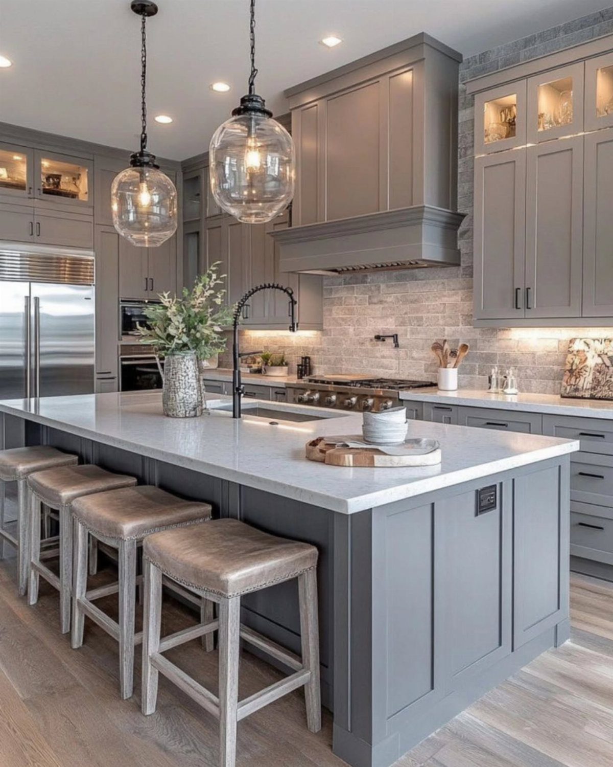 9 Kitchen Hardwood Flooring Ideas for Light to Bold Contrast 7 Modern kitchen with light gray cabinets, white marble island, and blonde wood flooring.