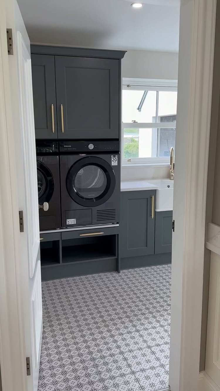 Patterned grey and white tiles covering the floor of a modern laundry room.