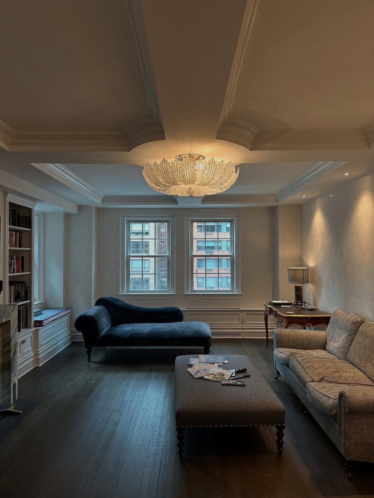 A living room with a tray ceiling, crystal chandelier, and decorative crown moulding.