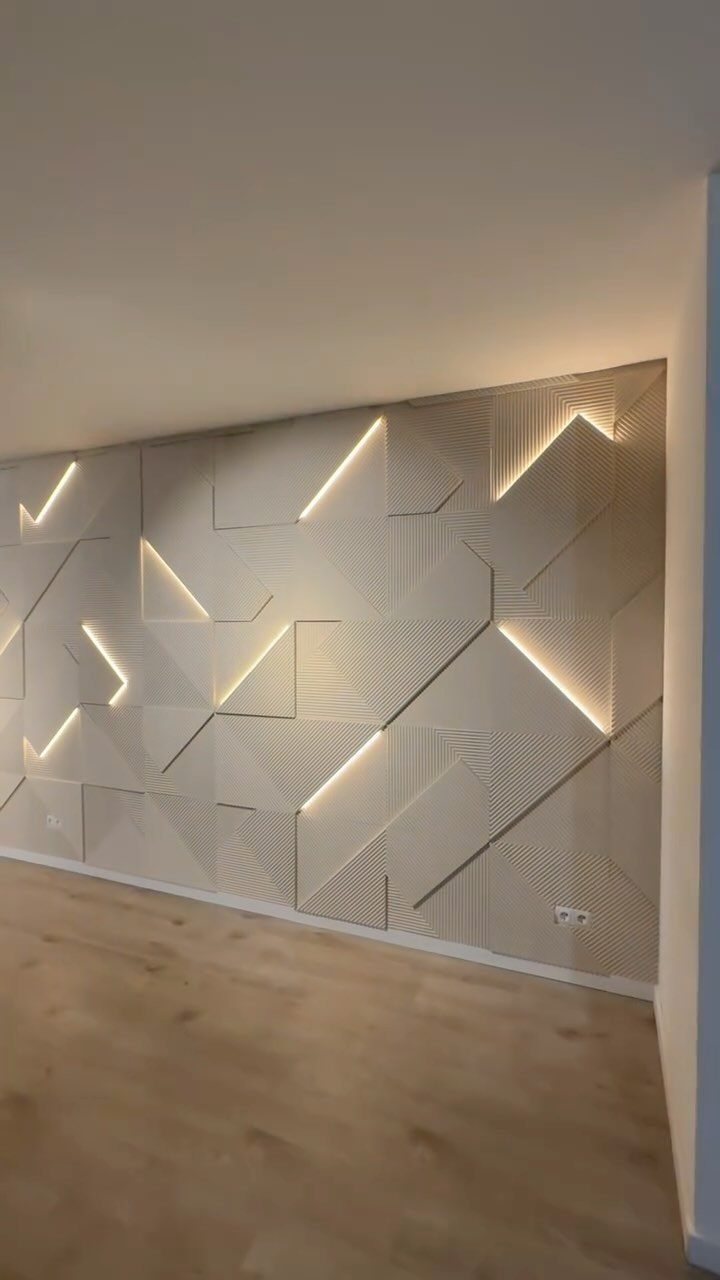 Geometric beige wall paneling with integrated LED strip lighting and various textured patterns in a room.