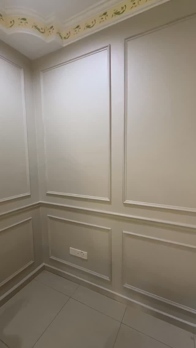 Beige wall molding with large rectangular panels covering the walls from floor to ceiling.