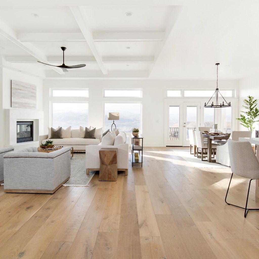 Most Popular Coretec Colors: 8 Best-Selling Flooring Picks 2 Light wood flooring in a bright, modern open-concept living and dining room with white walls.
