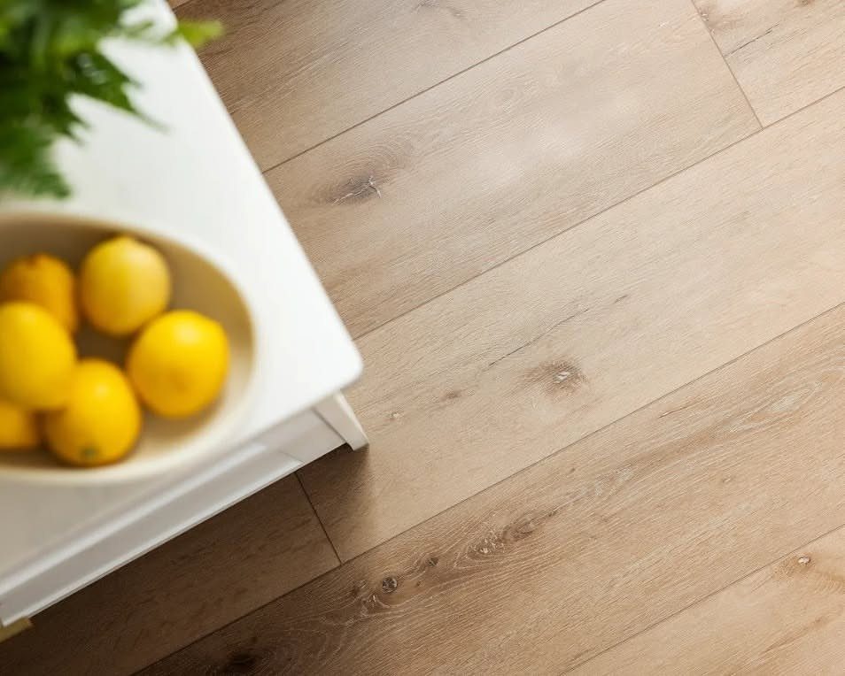 Most Popular Coretec Colors: 8 Best-Selling Flooring Picks 3 Light wood flooring planks next to a white table with a bowl of yellow lemons.