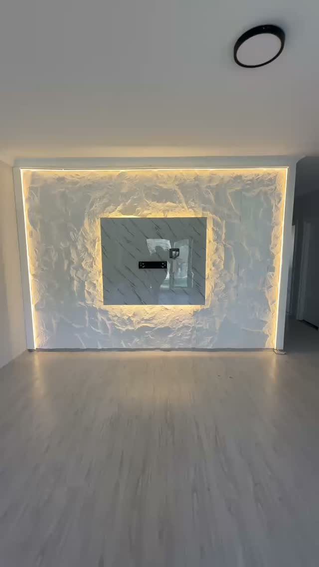 White 3D textured wall with integrated LED lighting and a central rectangular mirror.