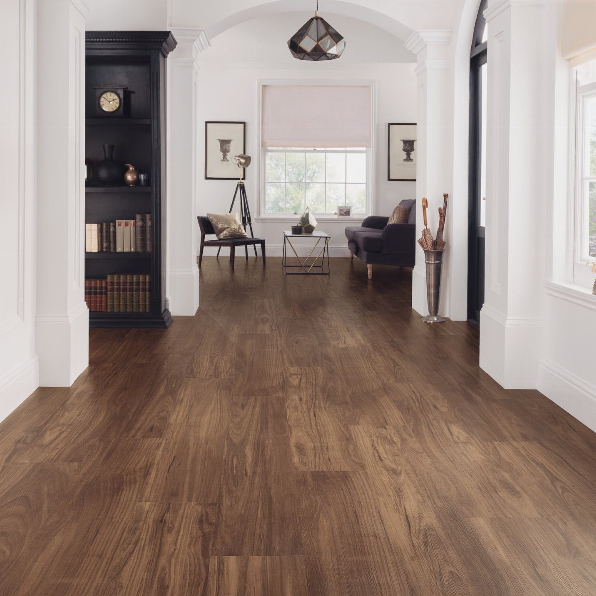Dark walnut hardwood flooring stretching through a bright room with white walls and architectural trim.