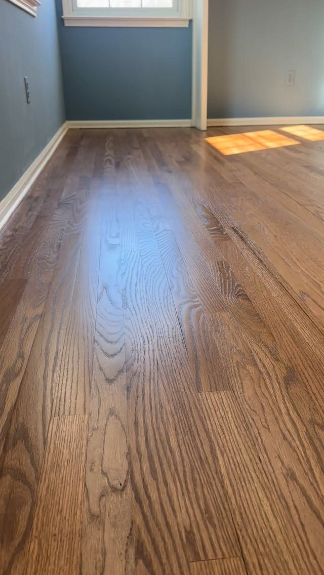 Polished hardwood floor planks with visible grain patterns in a room with blue walls.