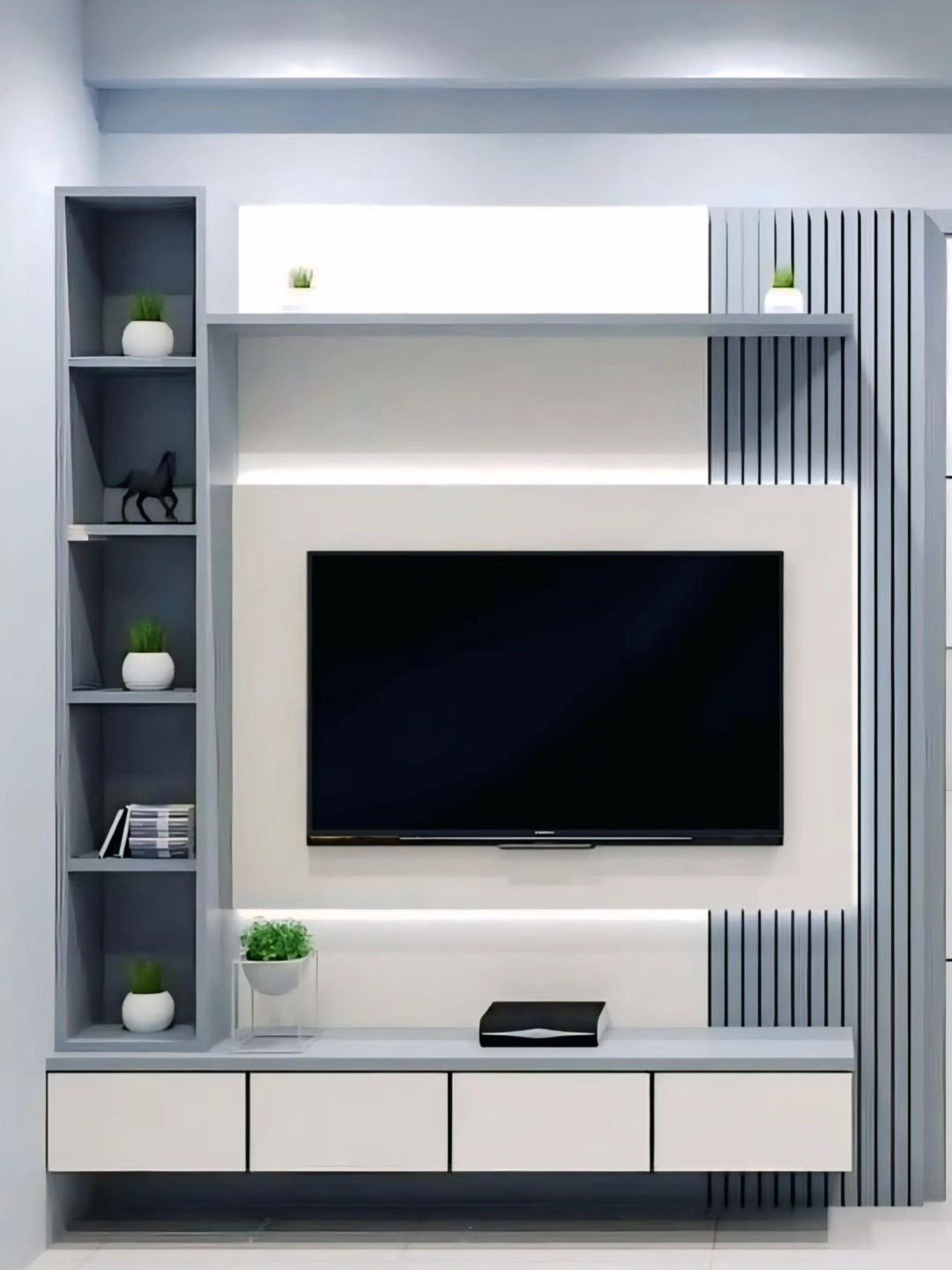 A modern grey and white media wall unit with a large television and built-in shelving.