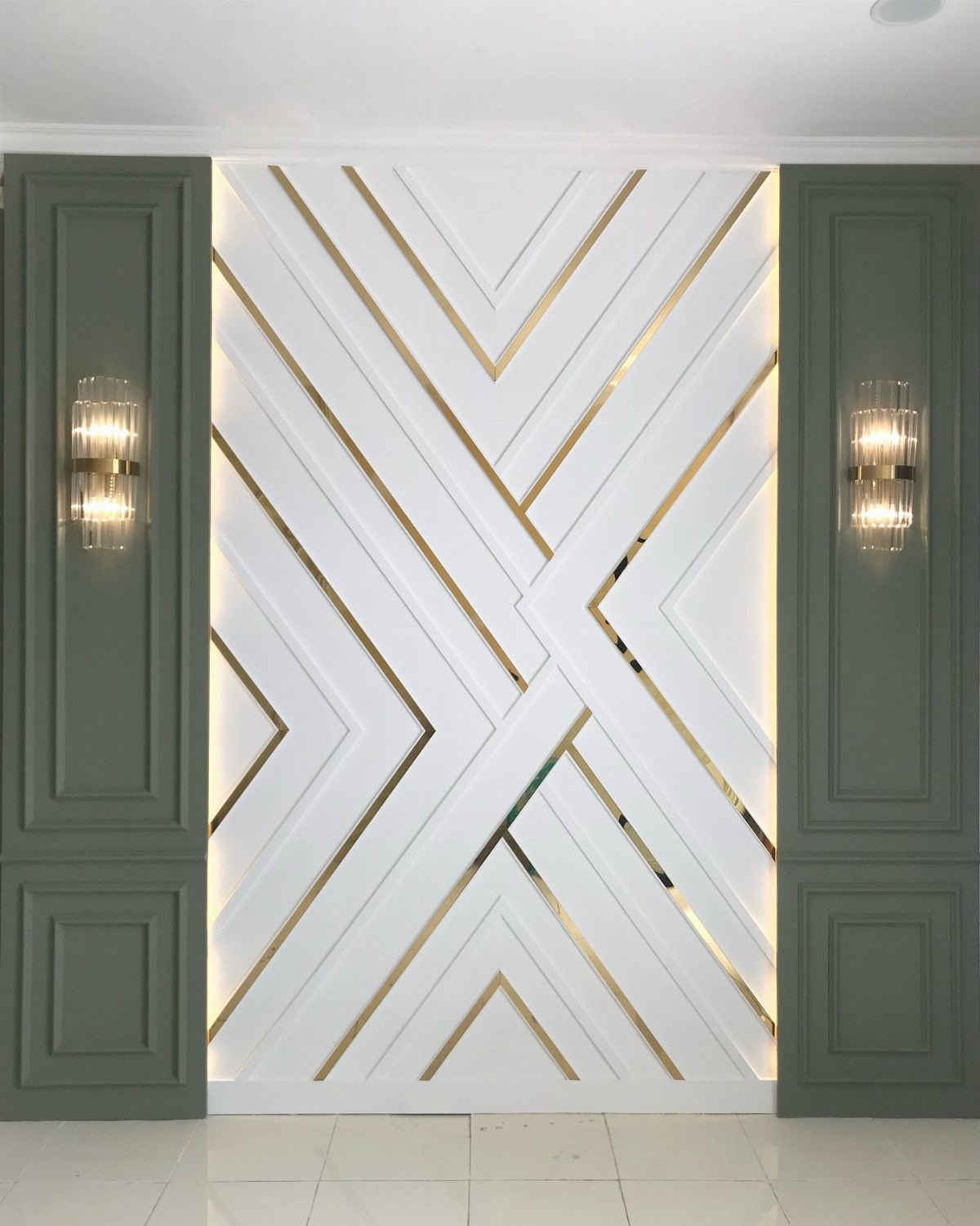 8 Wall Molding Design Ideas for Rooms That Need More Structure 8 Geometric white wall with gold diagonal lines and integrated lighting between green paneled walls.