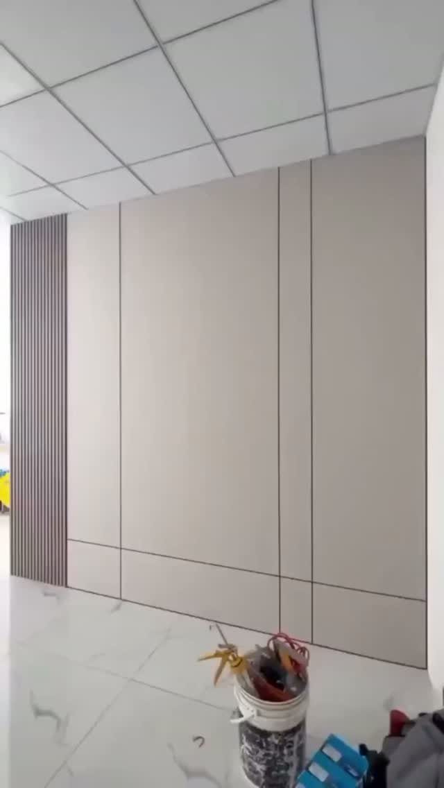 Light grey rectangular wall panels with dark grooves and a section of vertical wooden slats.
