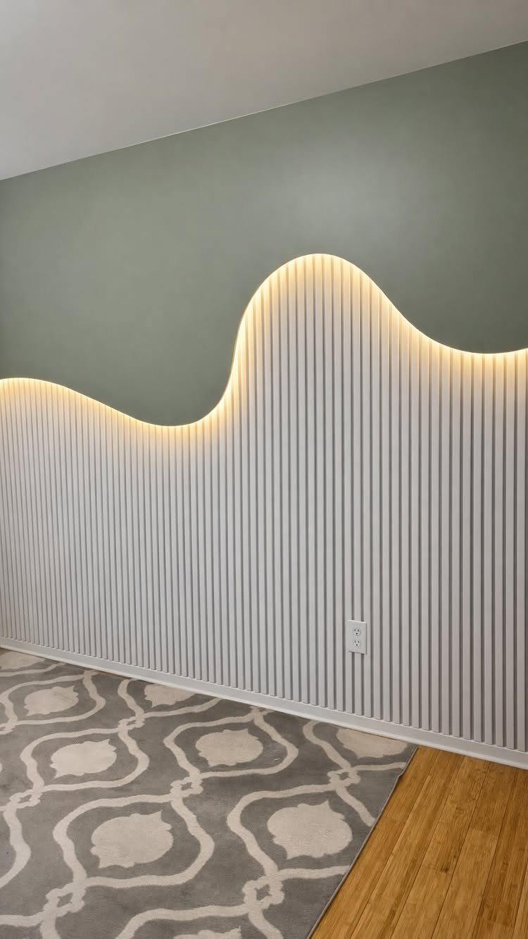 White vertical wood slats arranged in a wavy pattern against a sage green wall.