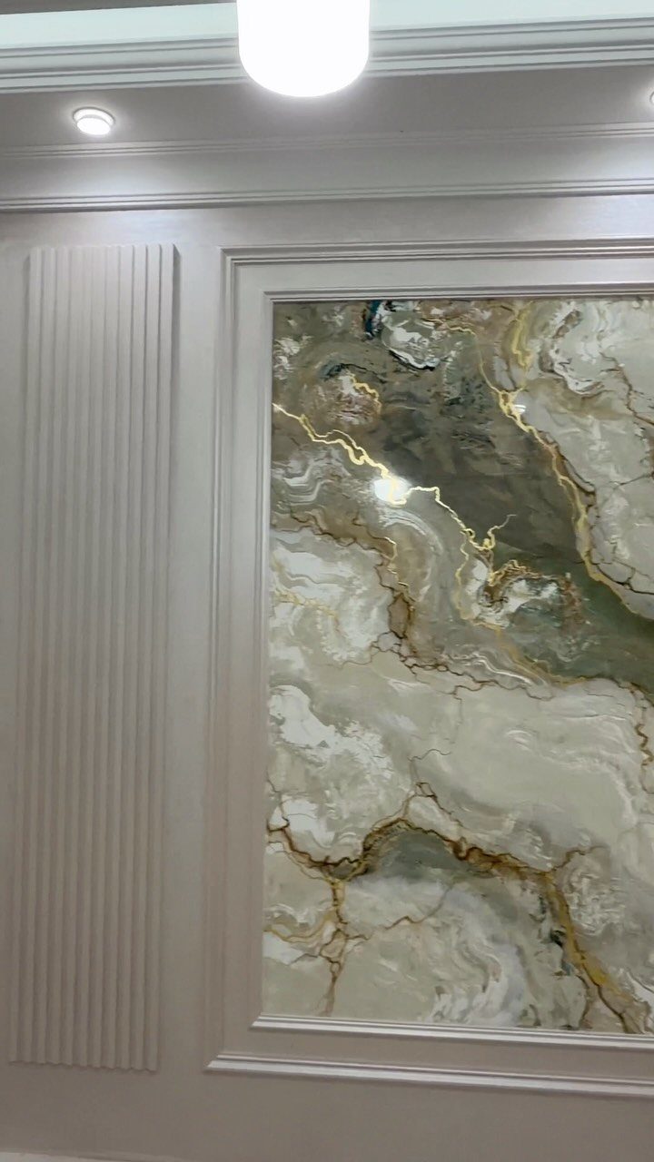 Decorative grey wall molding featuring vertical fluted panels and a large framed marble pattern.