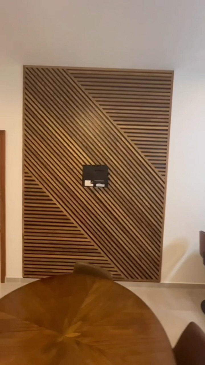 A wooden accent wall with a geometric pattern of diagonal and horizontal slats.
