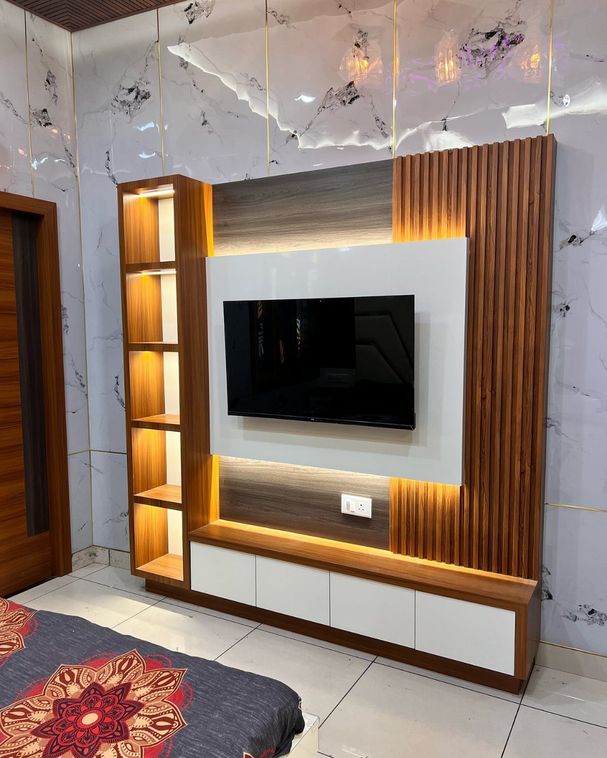 Modern entertainment unit with integrated LED strip lighting behind wood and white wall panels.