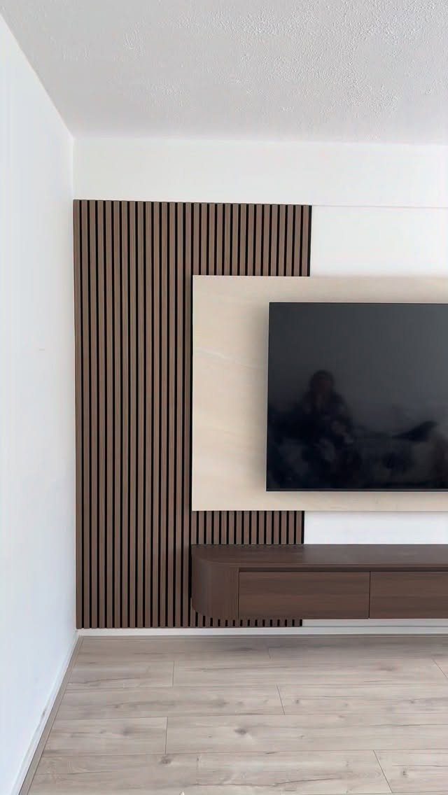 Vertical dark wood slats on a feature wall behind a television and floating console.