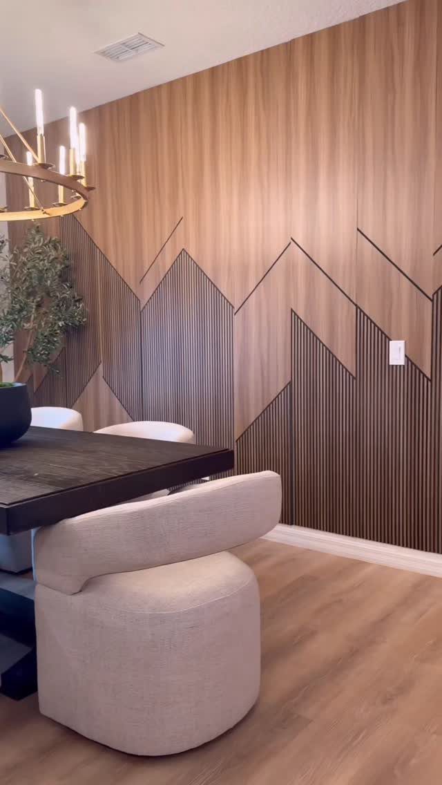Geometric mountain pattern wood wall design in a modern dining room setting.